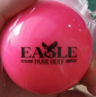 Pink golf ball with 'Eagle Park Golf' branding.