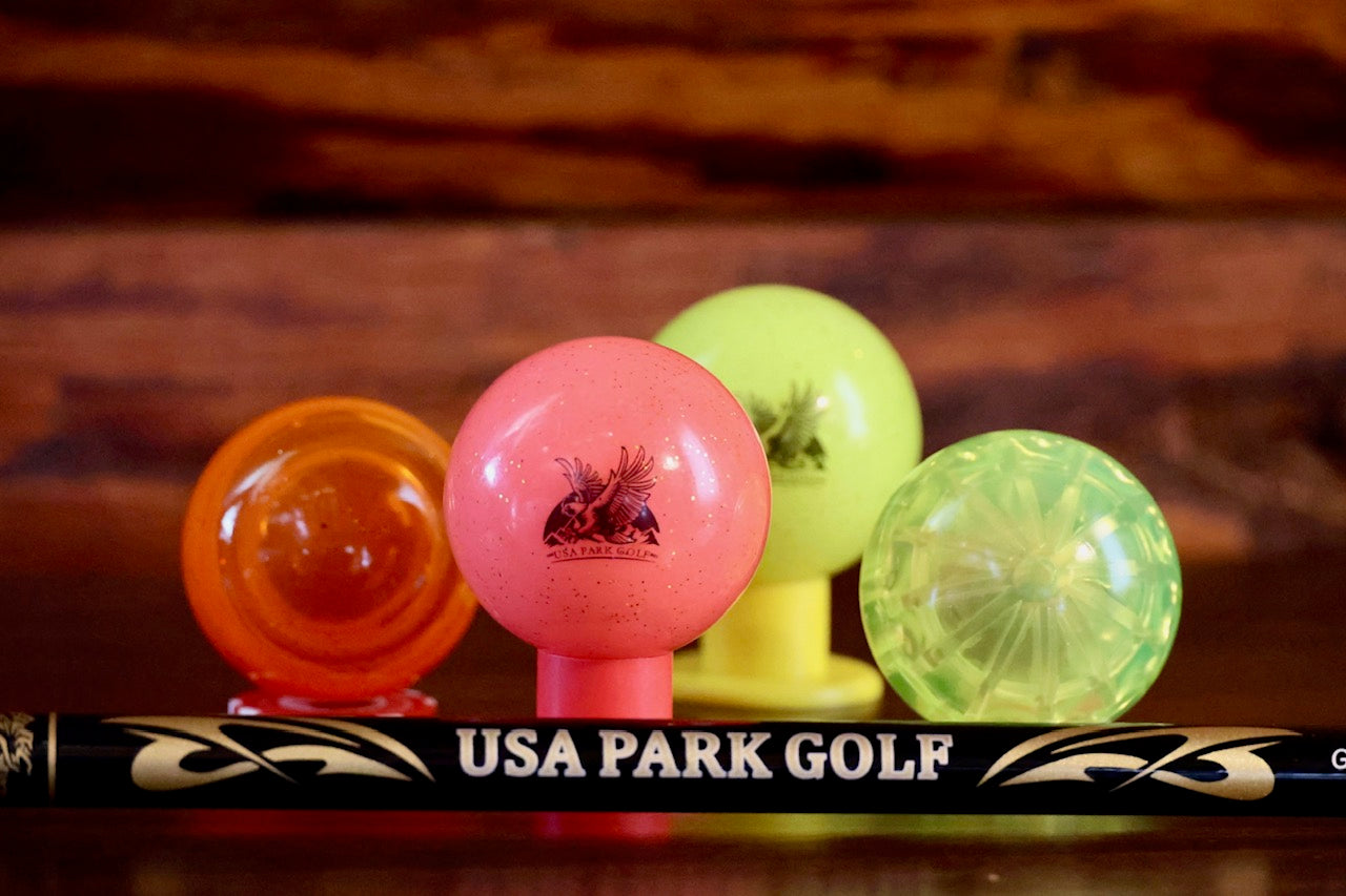 bright colored balls with a usa park golf shaft in front