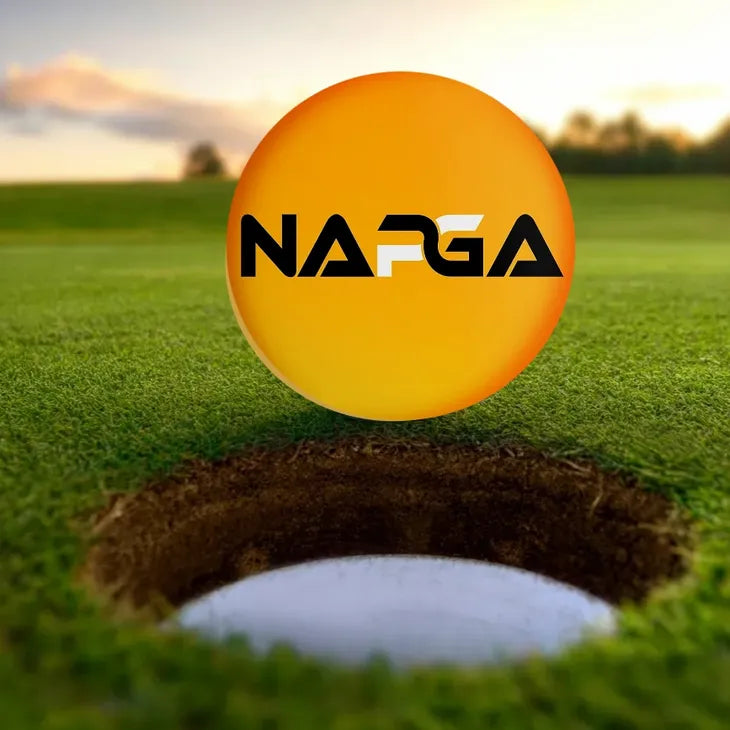 Park Golf ball with NAPGA logo hovering over a golf hole on a park golf course .